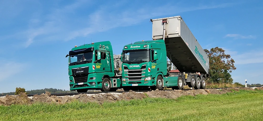 Zentler LKWs der Marke Scania und MAN beim Abladen auf einer Baustelle